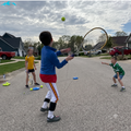 Kids practicing tennis on a street with solo trainers